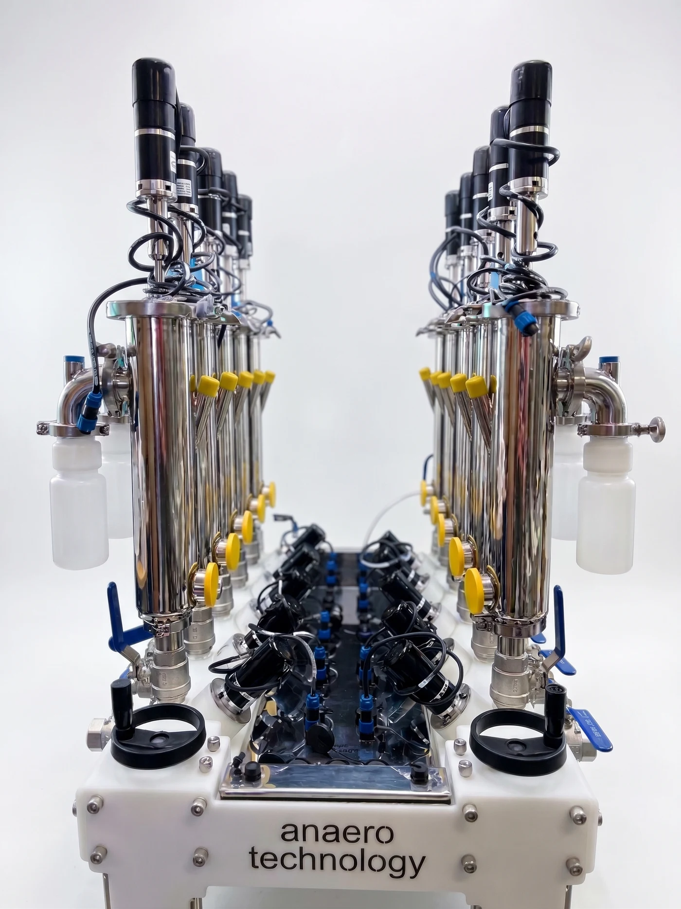 Two parallel rows of stainless steel Caterpillar reactors with mixer motors and sampling ports